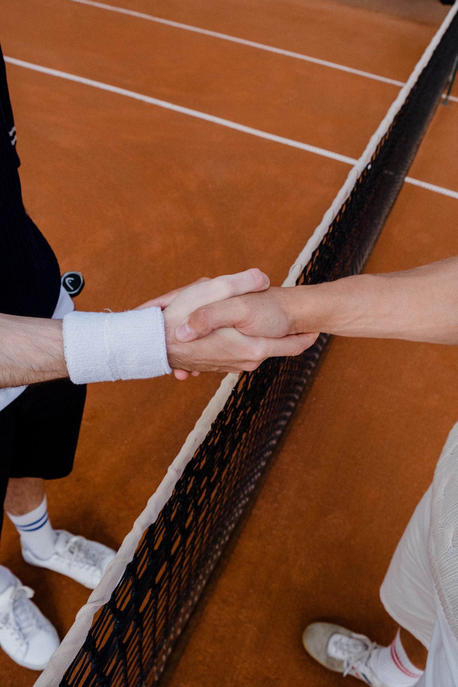 Tennis players shake hands over the net